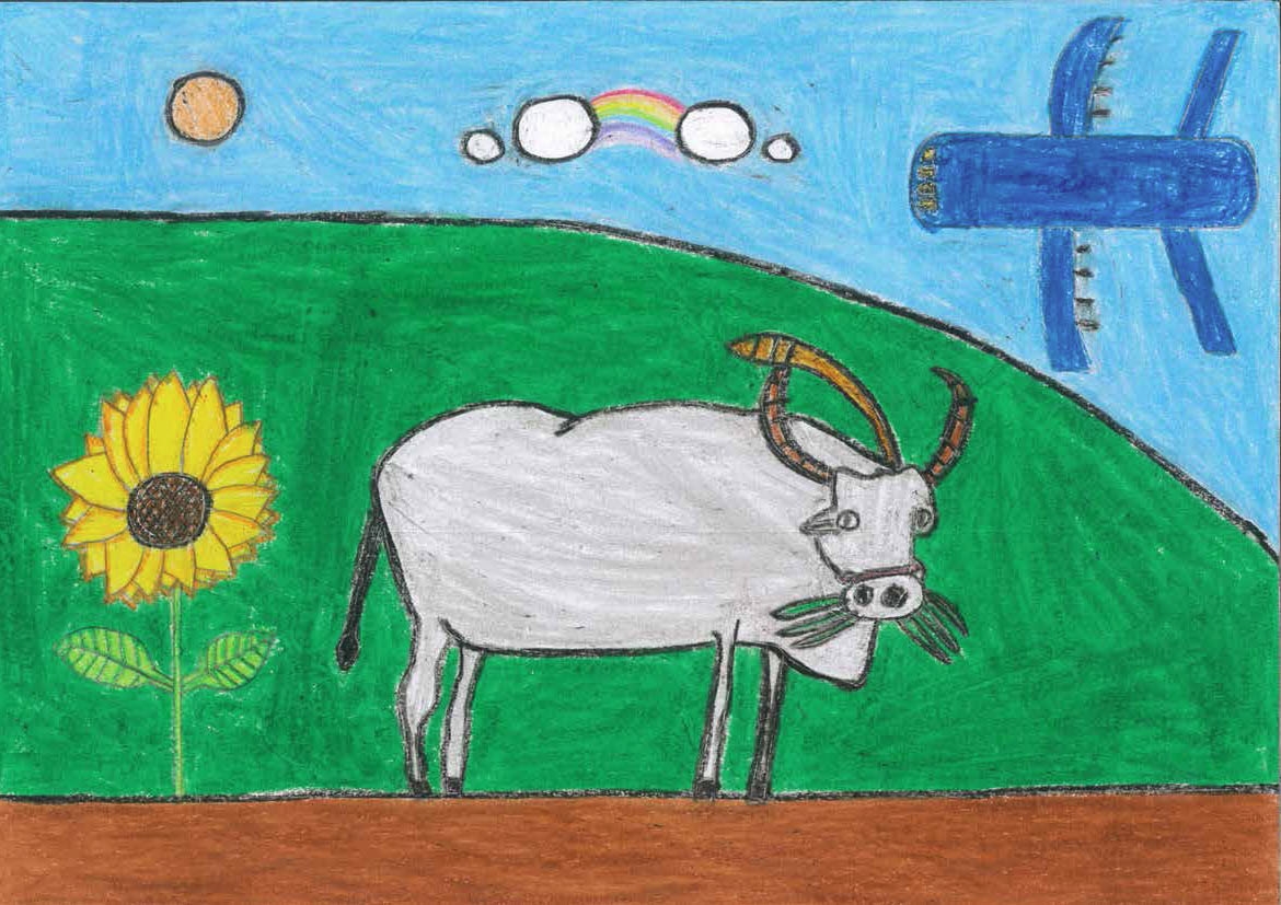 一隻水牛在草地上吃著草，旁邊有向日葵陪著他。